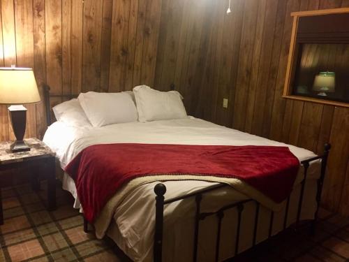 a large bed in a room with wooden walls at Tillie Creek Retreat: a Creekside Oasis in Wofford Heights