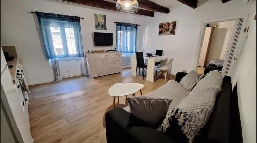 uma sala de estar com um sofá e uma mesa em Charmant appartement de village rénové em Gorbio