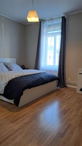 a bedroom with a bed and a large window at Chambre tout confort in Annappes