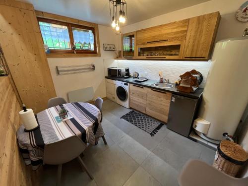 a small kitchen with a table and a sink at Chalet coup de coeur in Passy