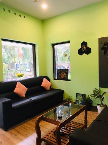 a living room with a black couch and a coffee table at Lavender residency in Varkala