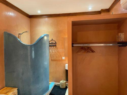 a bathroom with a shower and a blue door at RIAD LAICHI in Marrakech