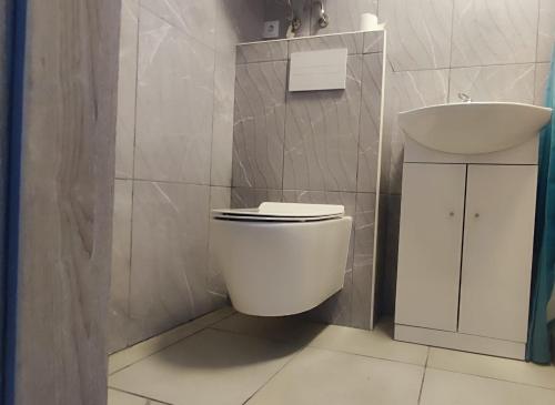 a bathroom with a white toilet and a sink at Burtnieku 33 in Rīga