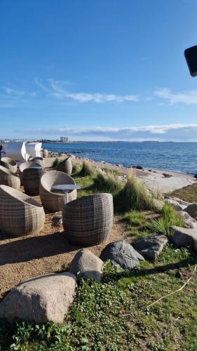 a group of tables and rocks next to the ocean at Wohnwagen auf dem Wulfenerhals ca 150m bis zum Meer in Fehmarn