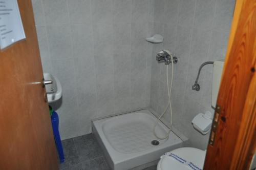 a small bathroom with a shower with a toilet at Olympion Village Studios in Zakharo