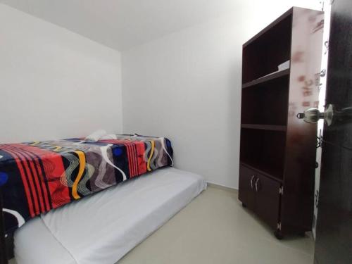 1 dormitorio con 1 cama junto a un armario en La mejor ubicación en el eje cafetero, en Armenia