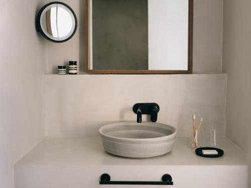 a white bathroom with a sink and a mirror at Mondrian Ibiza in Cala Llonga