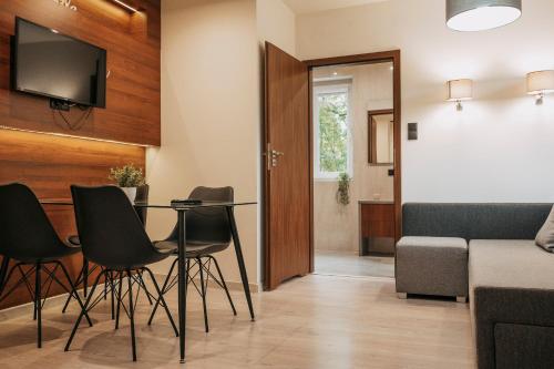 una pequeña sala de estar con mesa y sillas. en Niron Apartament Kapucyńska en Piła
