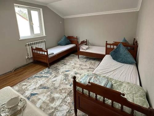 a room with three beds and a window at Joy in Atyrau