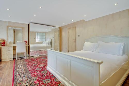 a bedroom with a bed and a desk and a mirror at Noel Oasis : London Retreat in London