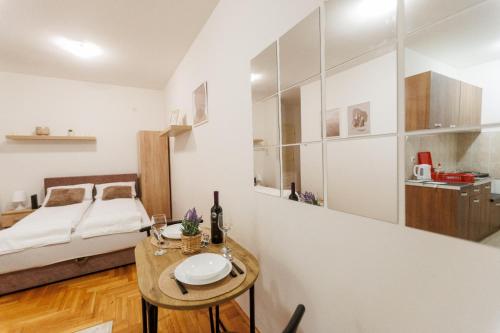 Cette petite chambre comprend un lit et une table avec une plaque de cuisson. dans l'établissement Apartman 369, à Subotica