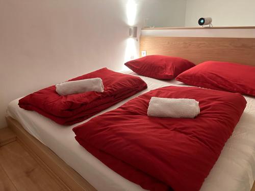 2 almohadas rojas en una cama en una habitación en Loft Apartment am Brunnenmarkt en Viena