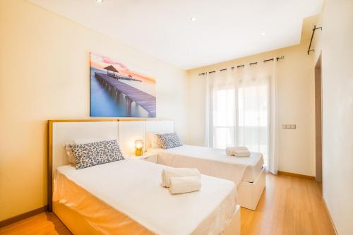 Un dormitorio con dos camas y un cuadro en la pared. en Cozy villa with pool and Barbecue, en Albufeira