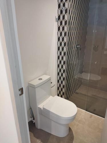 a white toilet in a bathroom with a shower at Distrito 90 in Barranquilla