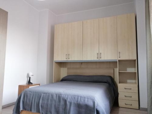 Schlafzimmer mit einem Bett und Holzschränken in der Unterkunft sant'orsola holiday home in Misterbianco