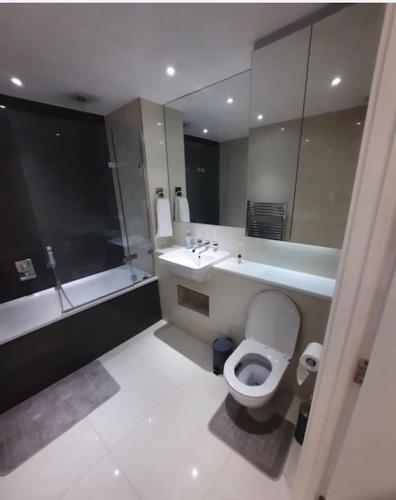 a bathroom with a toilet and a sink and a tub at Luxurious 3 Bedroom Flat Close To East Croydon Station - Gym - Sleeps 6 in London