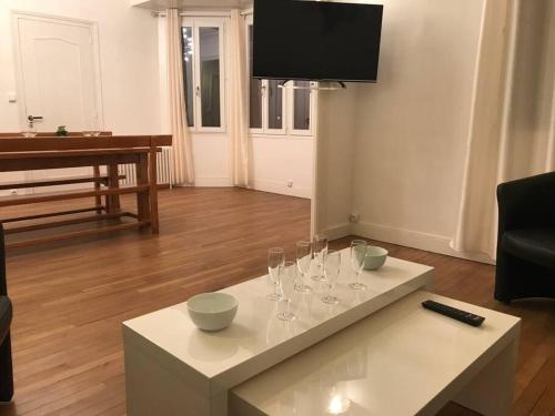 uma sala de estar com uma mesa com copos de vinho em Maison 8 P. Bien situé. Entrée et sortie facile. em Ruelle-sur-Touvre