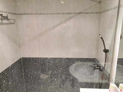 y baño con ducha y pared de azulejos. en Benicarlo Puerto, en Benicarló