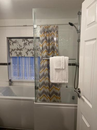 a bathroom with a shower and a shower curtain at HAMS LODGE - - Strictly Only ONE GUEST ALLOWED IN ONE ROOM A SECOND ACCOMPANYING PERSON WILL NOT BE ALLOWED INTO THE PROPERTY in Birmingham