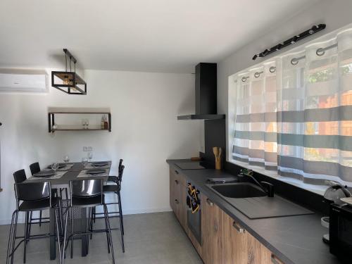 une cuisine avec un évier et une table avec des chaises dans l'établissement LA CASA, à Olby