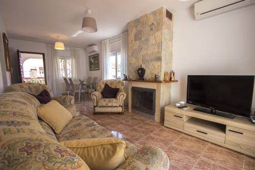 a living room with a couch and a flat screen tv at Catalunya Casas Tranquil nature "feel" , yet only 4 min to beach! in Calafell