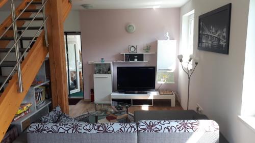 a living room with a couch and a television at Lepa Dolenjska in Uršna Sela