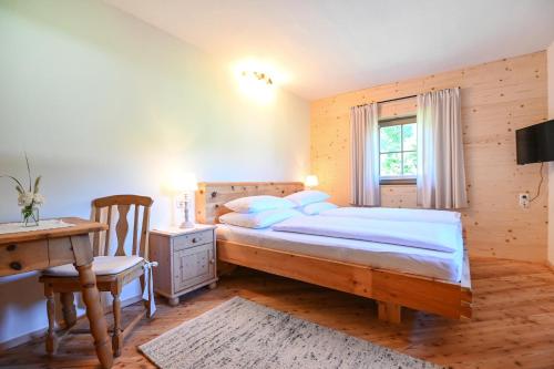 1 dormitorio con cama, escritorio y ventana en Auerhof en Schladming