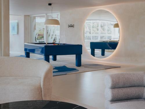 a living room with a pool table and a mirror at Mondrian Ibiza in Cala Llonga