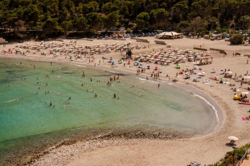 a group of people in the water at a beach at Mondrian Ibiza in Cala Llonga