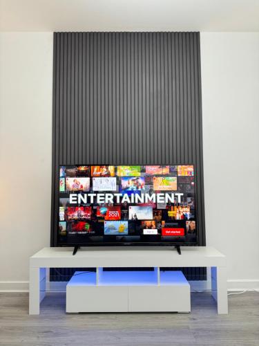 a flat screen tv sitting on top of a white table at Spanish City View 1, Stylish Sea Front Apartment Free Onsite Parking in Whitley Bay