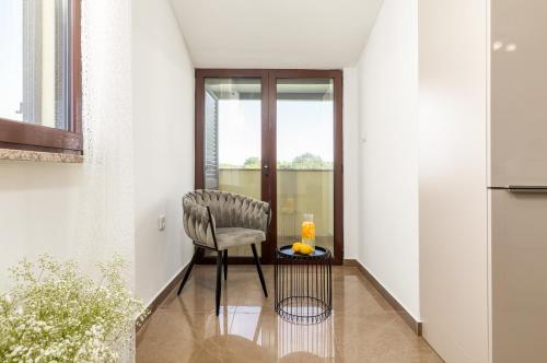 a chair sitting in a room with a table at Villa Miromar APP in Pula