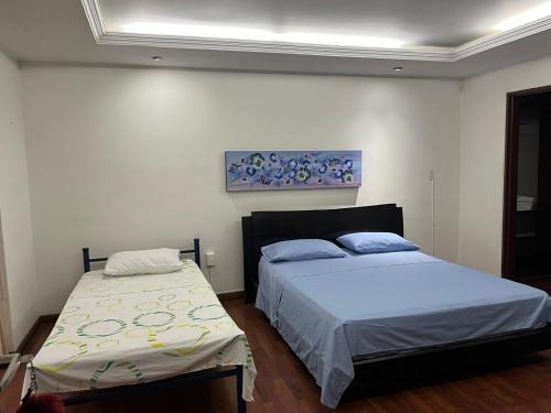 a bedroom with two beds and a painting on the wall at Casa independiente, ciudad jardín in Cali