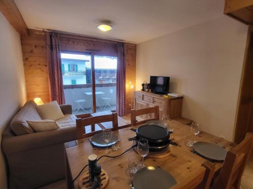 a living room with a table and a couch at Ecrins A4, 1 bedroom apartment with bunk room, central Samoëns in Samoëns
