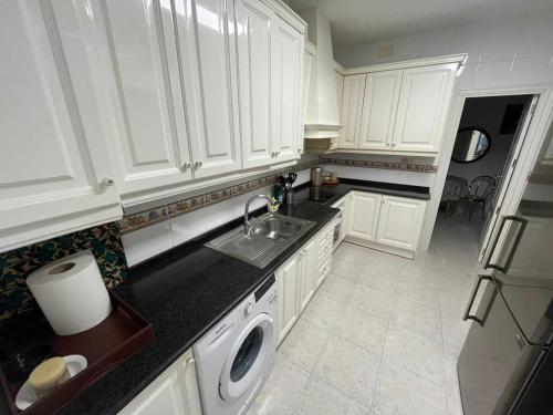 a kitchen with white cabinets and a sink and a dishwasher at R-1-Комната в квартире для 2 человек -Alicante centro in Alicante