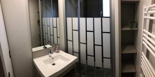 ein Badezimmer mit einem weißen Waschbecken und einem Spiegel in der Unterkunft Cottage Jullouville récent l'Edune résidence vacances - plage 150 m -piscine in Jullouville-les-Pins