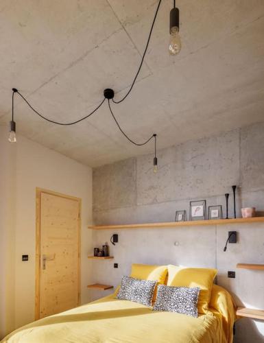 une chambre avec un lit avec un couvre-lit jaune dans l'établissement Maison contemporaine de plain-pied-Classée 3***, à Fréterive
