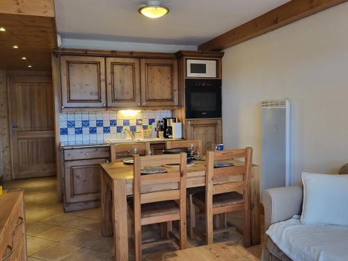 une cuisine avec une table et des chaises dans une pièce dans l'établissement Ecrins A4, 1 bedroom apartment with bunk room, central Samoëns, à Samoëns