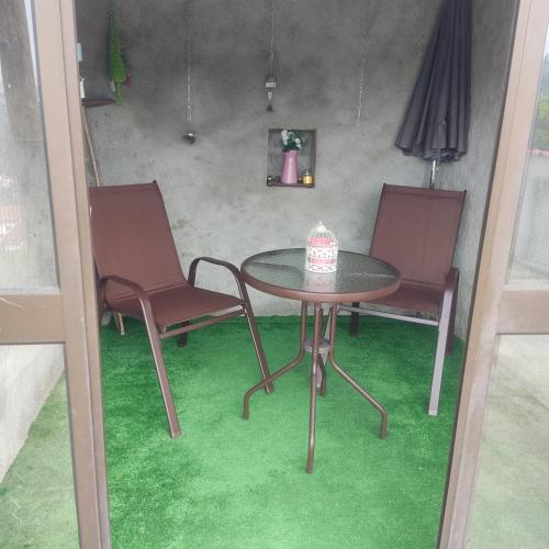 a table with two chairs and a table with a cake on it at Casinha da Sobreira in Penacova
