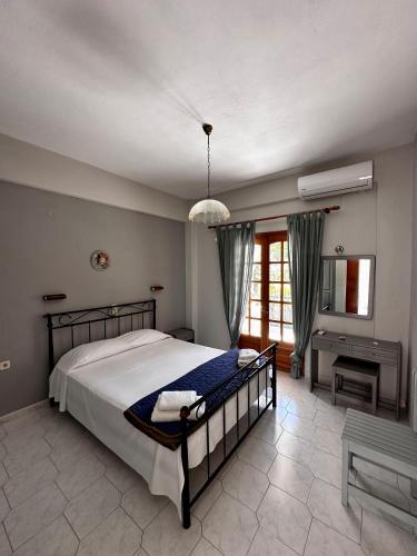 a bedroom with a large bed and a desk at Villa Spyros in Syvota
