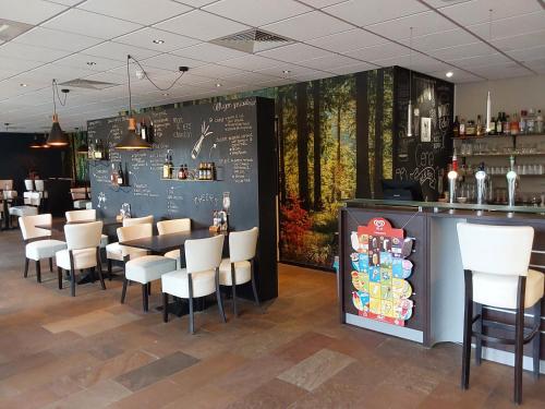 a restaurant with a chalkboard wall with a bar and chairs at Rumah Senang Wellness met hottub en tuin in Ewijk