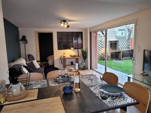 een keuken en een woonkamer met een tafel en stoelen bij L'atelier, appart avec jardin à 100 m de la mer. in Donville-les-Bains