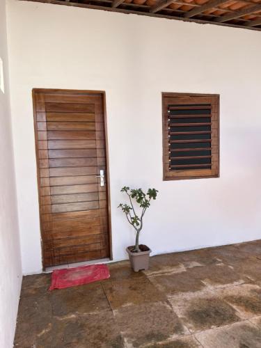 a room with a wooden door and a potted plant at Reis Veloso in Parnaíba