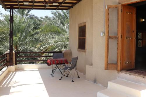 a patio with a table and a laptop on it at Misfah Old House in Misfāh