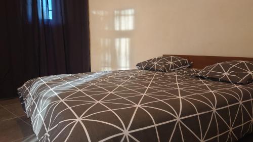 - un lit noir et blanc avec 2 oreillers dans l'établissement Appartement de la tour, à Connaux