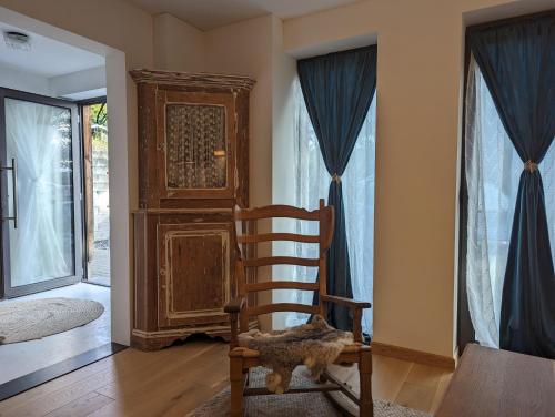 mecedora de madera en una habitación con puerta en Gîte des Genêts en terrasses, en Bièvre