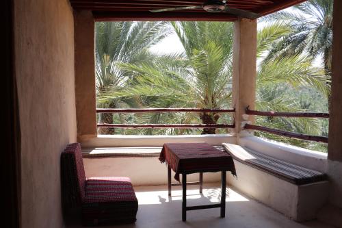 a room with a window with a table and chairs at Misfah Old House in Misfāh