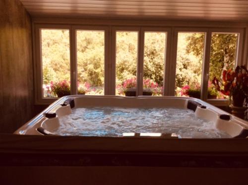 bañera grande en una habitación con ventanas en Les Jardins Corbès, en Corbés