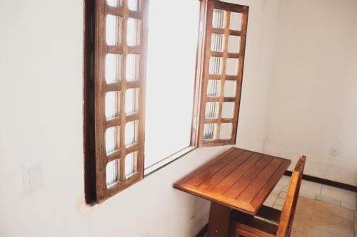 un banco de madera en una habitación con ventana en Hotel Estalagem Sertaneja, en Brumado