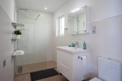 biała łazienka z umywalką i toaletą w obiekcie Luxury sea view apartment & pool w mieście Mijas
