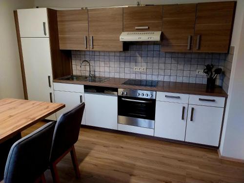 a kitchen with white appliances and a wooden table at Appartement Kieler in Haus im Ennstal